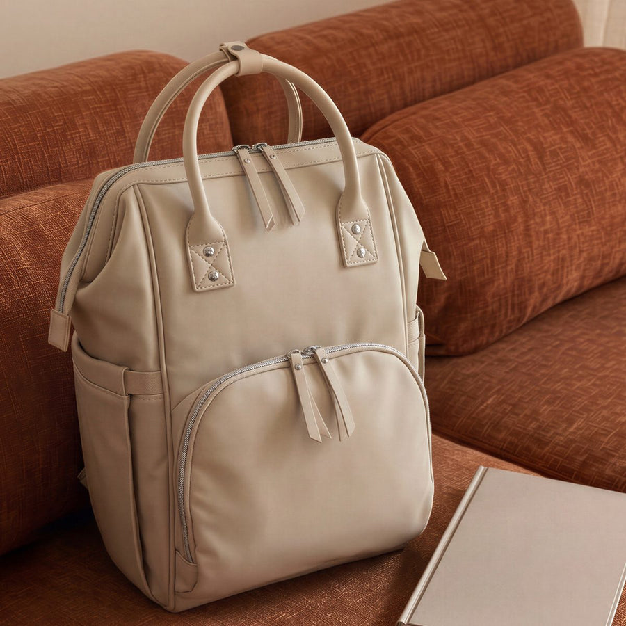 Stone ALUXO Active X baby bag resting on a terracotta sofa
